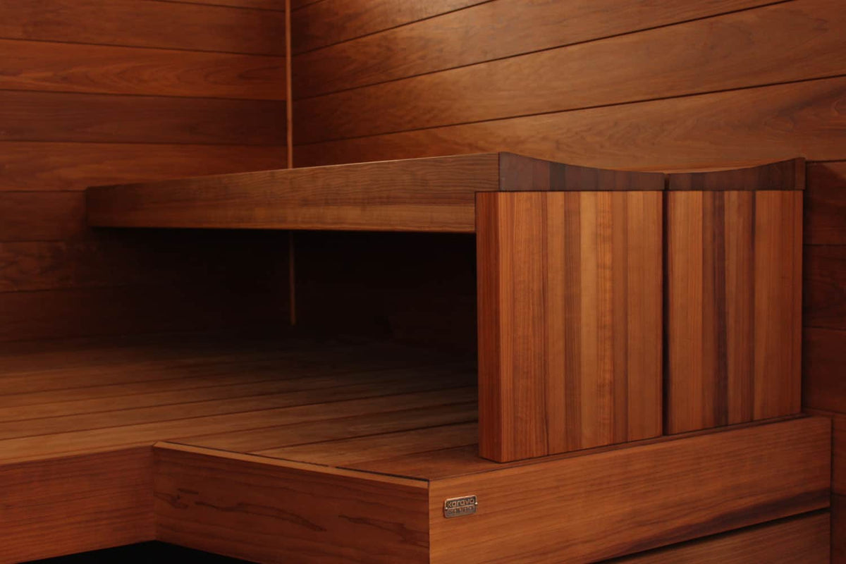 A close view of a sauna bench corner in thermo-treated aspen, showing the bench edge profile and the back rest